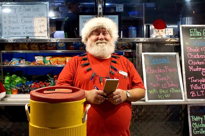 Jim "Kris Kringle" Carey served food at the Howey-in-the-Hills Christmas Festival on Friday and Saturday at Griffin Park on the shores of Little Lake Harris. [LINDA CHARLTON / CORRESPONDENT]