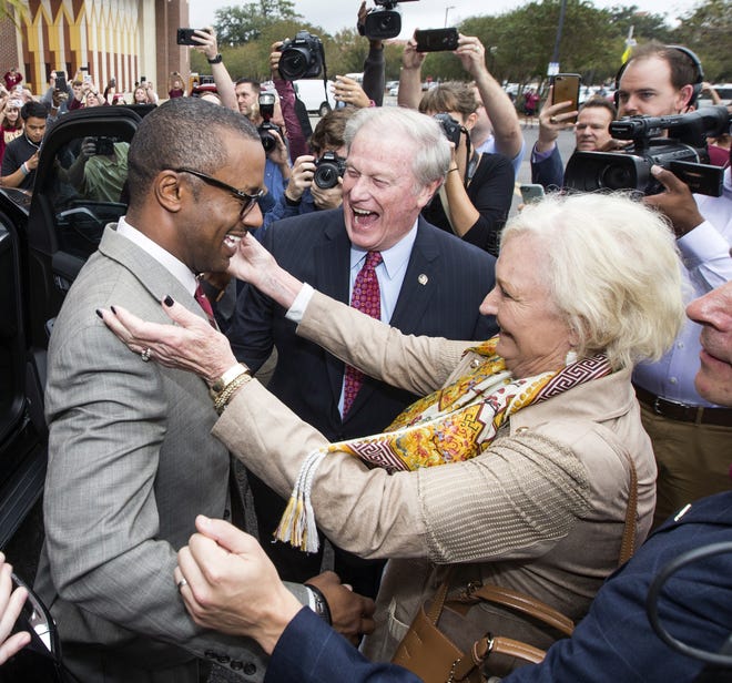 Willie Taggart, left, is greeted by Florida State University president John Thrasher and his wife, Jean, before being introduced as the school's new football head coach in Tallahassee on Wednesday. [AP Photo / Mark Wallheiser]