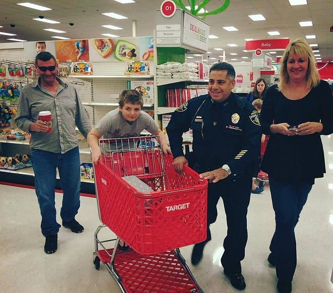 A Mount Dora officer helps a Shop With a Cop participant during a 2014 event. [Facebook]