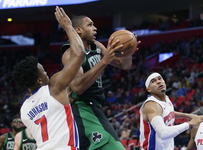 Boston Celtics forward Al Horford, center, goes to the basket against Detroit Pistons forwards Stanley Johnson (7) and Tobias Harris, right, during their game Sunday in Detroit. [Photo by AP]