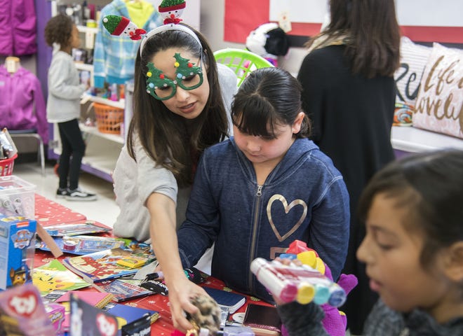 Volunteer Rina Miranda, left, helps student Vanessa Chavez, 8, shop at the Sea Star Emporium student store at Westwood Elementary School in Stockton. The Sea Star Emporium first opened in 2016 as a partnership between St. Mary’s High School senior Sofia Robles and the Junior League of San Joaquin County. [CLIFFORD OTO/THE RECORD]