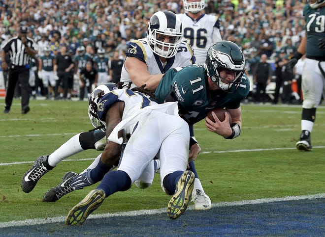 Philadelphia Eagles quarterback Carson Wentz gets tackles during the second half of an NFL football game against the Los Angeles Rams Sunday, Dec. 10, 2017, in Los Angeles. Wentz left the game shortly after the play and did not return to the game. (AP Photo/Mark J. Terrill)