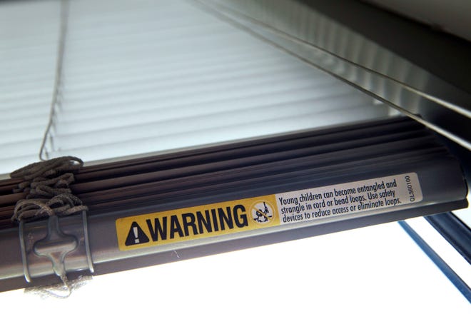 FILE - This Wednesday, May 6, 2015 file photo shows a warning label of strangulation risks from mini blind cords in Washington. According to a study released on Monday, Dec. 11, 2017, children's injuries and deaths from window blinds have not stalled despite decades of safety concerns. (AP Photo/Jacquelyn Martin)