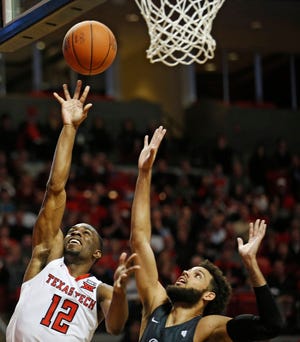 Texas Tech’s Keenan Evans (12) lays up the ball around Nevada’s Cody Martin (11) during the second half of an NCAA college basketball game Tuesday, Dec. 5, 2017, in Lubbock, Texas. (AP Photo/Brad Tollefson)