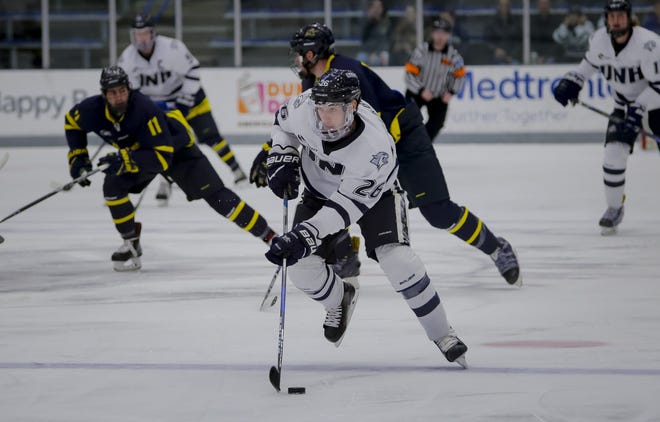 New Hampshire's Liam Blackburn, center, carries the puck during Sunday's Hockey East game against Merrimack at the Whittemore Center. After a hot start, the Wildcats finished 4-5-1 in conference play during the first half of the season. [Shawn St. Hilaire/Fosters.com]