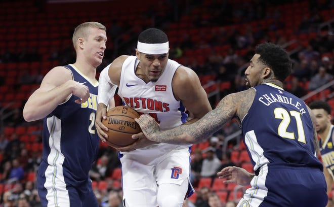 Detroit Pistons forward Tobias Harris, center, drives between Denver Nuggets center Mason Plumlee, left, and forward Wilson Chandler, right, during the first half of an NBA basketball game, Tuesday, Dec. 12, 2017, in Detroit. (AP Photo/Carlos Osorio)
