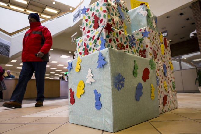 Overdue book fines accumulated by District 186 students are posted on a stack of wrapped gift packages at Lincoln Library. Generous patrons can pay off any of the fines as a holiday gift to the student. The display was photographed Thursday, Dec. 7, 2017. [Rich Saal/The State Journal-Register]