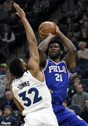 Minnesota Timberwolves center Karl-Anthony Towns (32) guards Philadelphia 76ers center Joel Embiid (21), of Cameroon, during the first quarter of an NBA basketball game on Tuesday, Dec. 12, 2017, in Minneapolis. Towns was called for a foul on the play. (AP Photo/Hannah Foslien)