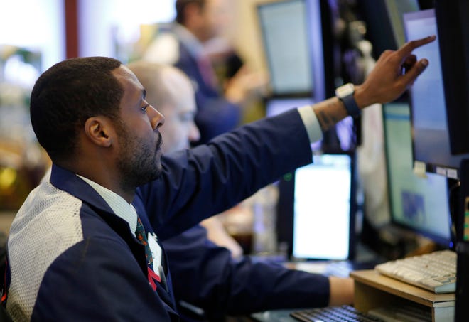 Stock trader Aaron Ford works Wednesday at the New York Stock Exchange. [AP PHOTO / MARK LENNIHAN]