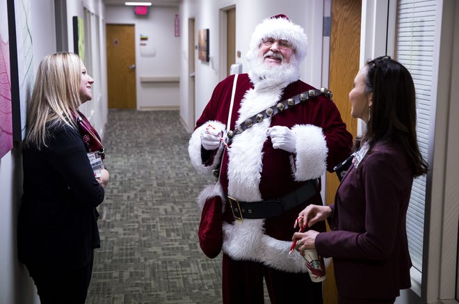 Bob Teel, who has portrayed Santa for 20 years, talks with Nicole Lowder, clinic nurse, left, and Kimberly Paskiewicz, director of the Memorial Weight Loss and Wellness Center on Wednesday. [Rich Saal/The State Journal-Register]