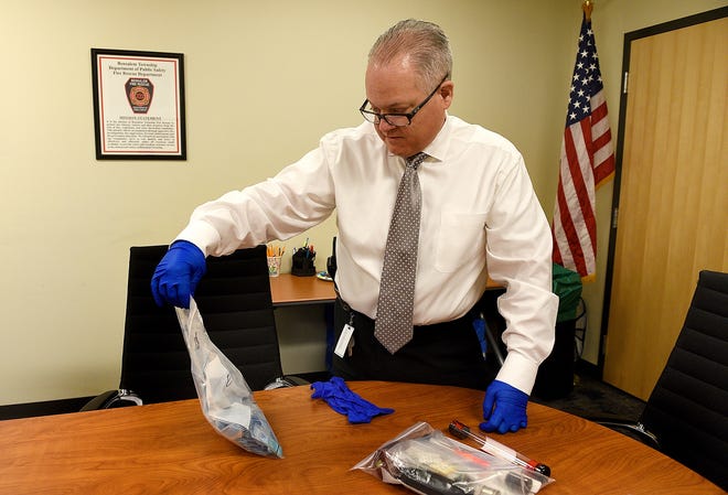 Fred Harran, director of public safety with the Bensalem Police Department, looks over a confiscated bag of heroin and other related paraphernalia in his office in Bensalem on Thursday, Dec. 14, 2017. Methamphetamine is making a comeback in the region, and it may be tied to the growing heroin epidemic, local law enforcers say. [KIM WEIMER / STAFF PHOTOJOURNALIST]
