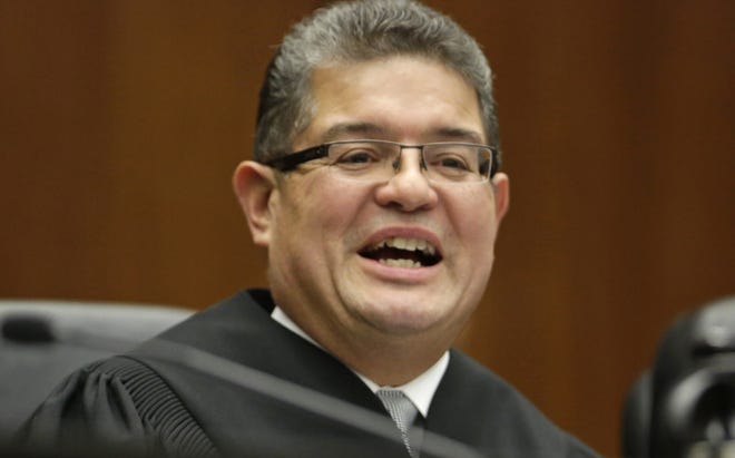 FILE - In this Nov. 25, 2013 file photo, Chief U.S. District Judge Ruben Castillo speaks from the bench in Chicago. A question raised nationwide about whether federal agents display racial bias by staging phony stash-house stings overwhelmingly in black neighborhoods is the focus of landmark hearings in Chicago.A rare panel of federal trial judges including Castillo begins two days of hearings Thursday Dec. 14, 2017, on the stings. (AP Photo/M. Spencer Green File)