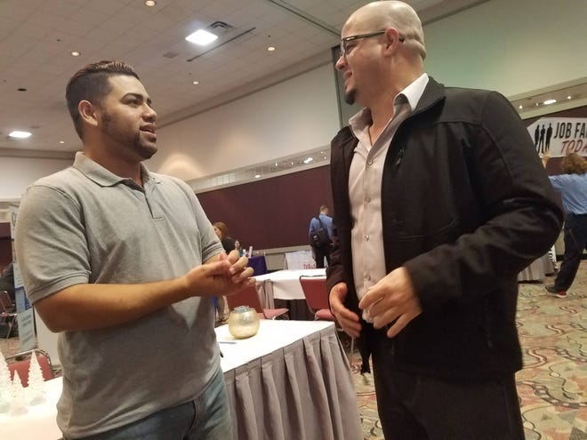 Melwin Nieves, left, and Jesus Lopez both volunteer with the Puerto Rican-Hispanic Chamber of Commerce of North Florida at a recent job fair in Jacksonville. (Florida Times-Union/Drew Dixon)