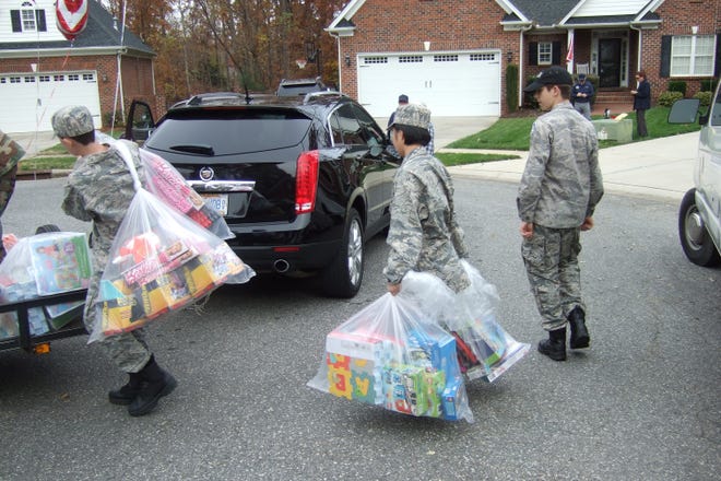 Uniformed teens from the Gastonia Civil Air Patrol collect about 400 new toys donated by Linda McCusker at her Gastonia home on Nov. 25. They later transported the toys to the U.S. Marine Corps League’s Toys for Tots collections warehouse, from where they will be donated to needy children in Bessemer City, Dallas and Cherryville. [GREG MCCUSKER/SPECIAL TO THE GAZETTE]