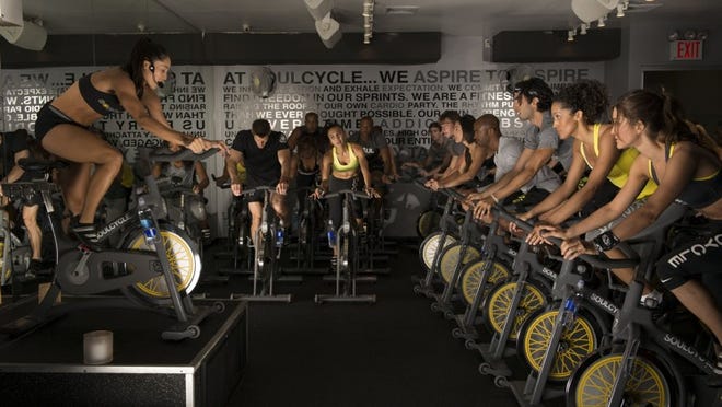 A SoulCycle class underway in downtown Austin, Texas. Classes take place on special bikes and include hand weights and core exercises for a full-body workout. (Courtesy of SoulCycle)
