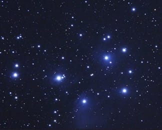 The famous Pleiades star cluster is easily visible to unaided eyes on a December evening. This is part of a larger picture that also showed a passing comet in 2005. [Rochus Hess/ Wikimedia Commons]