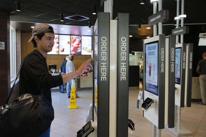 A man orders food from a self-service kiosk at a McDonald's restaurant in Chicago. [AP Photo/Charles Rex Arbogast]