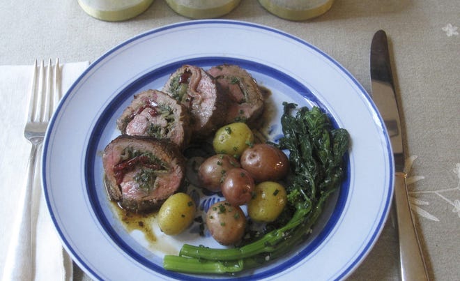 The petite beef filet is stuffed with prosciutto, pesto and roasted red peppers. [AP photo]
