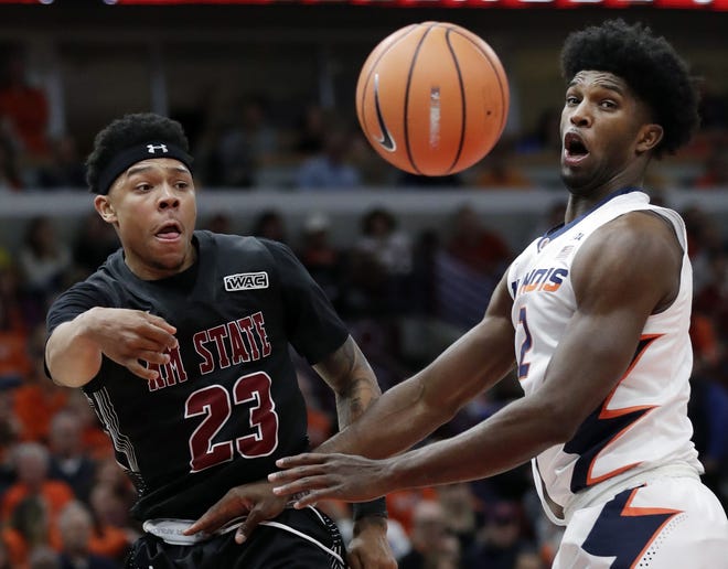 New Mexico State guard Zach Lofton, left, passes against Illinois forward Kipper Nichols during the first half of an NCAA college basketball game Saturday, Dec. 16, 2017, in Chicago. [NAM Y. HUH/THE ASSOCIATED PRESS]