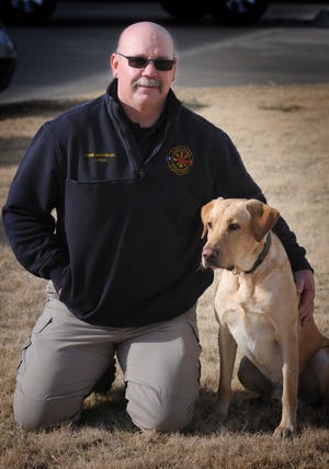 Fire Marshal Troy Long with Hoke, the Salina Fire Department's arson-sniffing dog. [TOM DORSEY / SALINA JOURNAL]