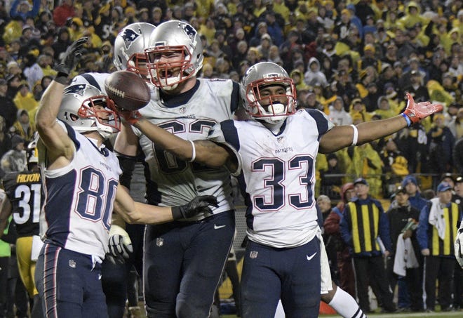 New England Patriots running back Dion Lewis (33) celebrates his touchdown during the second half of their game against the Pittsburgh Steelers in Pittsburgh on Sunday. [Photo by AP]