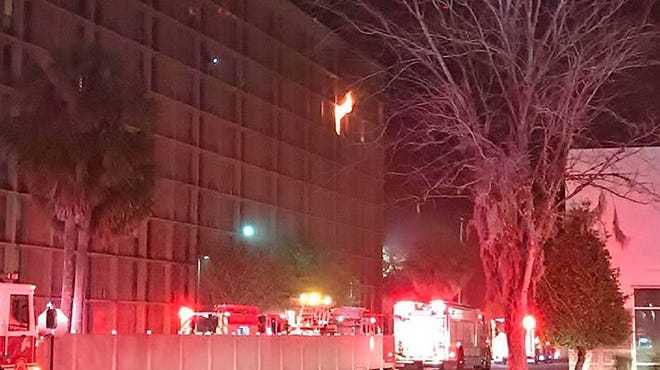 Flames leap out of an eighth floor apartment at the Jacksonville Townhouse Apartments on Philips Highway early Monday as fire units arrive to battle it and evacuate residents. (Jacksonville Fire and Rescue Department union)