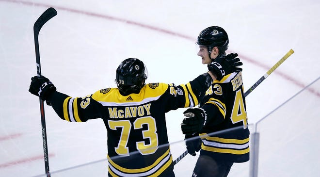 Bruins center Danton Heinen, right, is congratulated by Charlie McAvoy after his goal during the third period on Monday.
