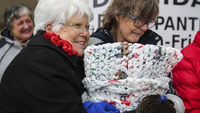 Calvary Lutheran Church volunteer Doris Wendland braces against the cold outside with Mosaic client Margaret Webb while they present mats they created from plastic grocery bags at Project Dignidad in San Angelo. (Yfat Yossifor / The San Angelo Standard-Times)