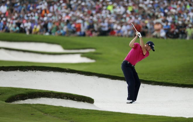Justin Thomas hits from the bunker on the 18th hole during the final round of the PGA Championship golf tournament at the Quail Hollow Club, in Charlotte, N.C., on Aug. 13, 2017. Thomas won his first major with key shots at the start and finish of the tournament. [AP Photo/Chuck Burton, File]