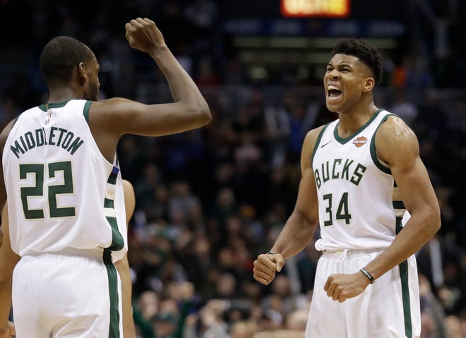 Milwaukee Bucks' Giannis Antetokounmpo celebrates with Khris Middleton (22) after making a basket and being fouled during the second half of an NBA basketball game against the Cleveland Cavaliers Tuesday, Dec. 19, 2017, in Milwaukee. The Bucks won 119-116. (AP Photo/Morry Gash)