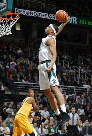 Michigan State's Miles Bridges goes up for a dunk against Long Beach State's LaRond Williams during the first half of an NCAA college basketball game, Thursday, Dec. 21, 2017, in East Lansing, Mich. (AP Photo/Al Goldis)