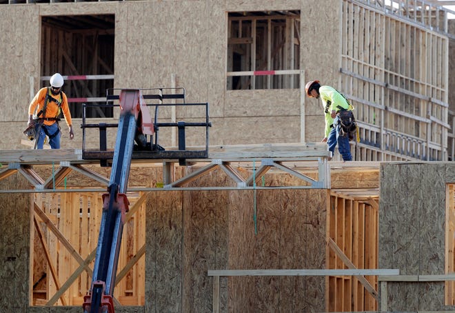 In this July 12, 2017, photo, construction workers build a residential complex in Nashville, Tenn. The U.S. economy grew at a 3.2 percent annual rate from July through September, slightly slower than previously estimated but still enough to give the country the best back-to-back quarterly growth rates in three years. (AP Photo/Mark Humphrey)