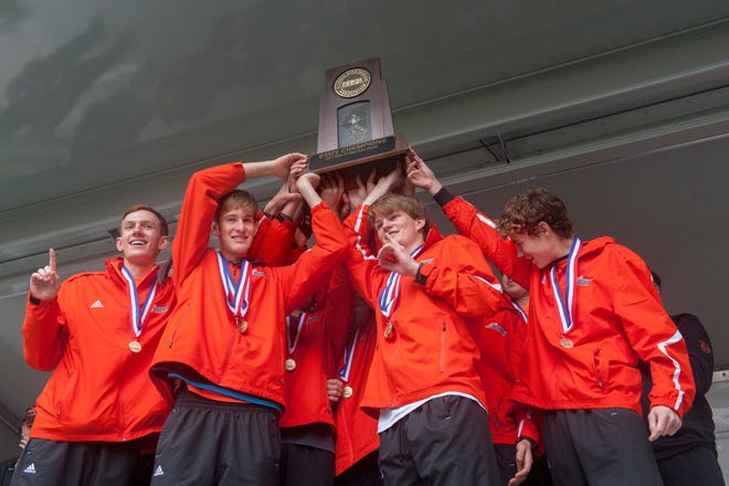 DAVID ZALAZNIK/JOURNAL STAR Elmwood/Brimfield cross country team members lift their trophy Saturday after winning the team competition in the IHSA State 1A Boys cross country finals Saturday at Detweiler Park in Peoria.