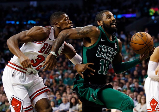 The Bulls' Kris Dunn takes an elbow to the face from the Celtics' Kyrie Irving as the Boston guard drives to the basket in the first quarter on Saturday.
