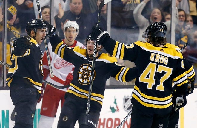 Boston's Patrice Bergeron, left, celebrates his goal with teammates including Torey Krug (47) during the third period of Saturday's game against the Detroit Red Wings in Boston.