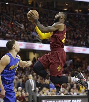 Cleveland Cavaliers' LeBron James (right) drives to the basket against Golden State Warriors' Klay Thompson in the first half of a game, Sunday, Dec. 25, 2016, in Cleveland. (AP Photo/Tony Dejak)