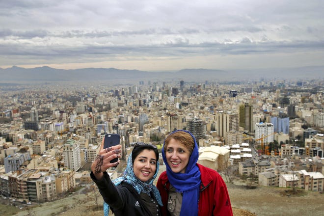 Women take selfies outdoors to observe the ancient festival of Sizdeh Bedar, an annual public picnic day on the 13th day of the Iranian new year, at the Tochal mountainous area northern Tehran, Iran, Sunday, April, 2, 2017. Sizdeh Bedar, which comes from the Farsi words for "thirteen" and "day out," is a legacy from Iran's pre-Islamic past that hard-liners in the Islamic Republic never managed to erase from calendars. (AP Photo/Ebrahim Noroozi)