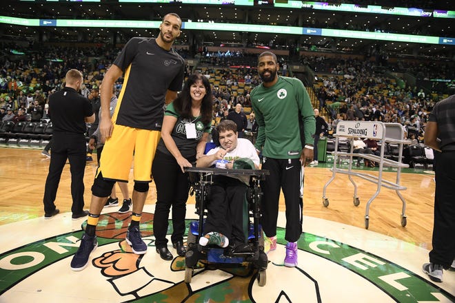 Posing at center court at the Celtics game against the Jazz Dec. 15 were, from left, Jazz center Rudy Gobert, Heroes Among Us honorees Lisa and Kyle Brodeur, and Celtics guard Kyrie Irving. [Photo/Boston Celtics]