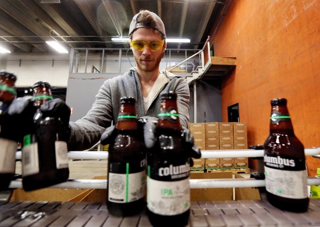 Seth Dumm packs bottles of beer for Columbus Brewing Co., the most-searched brewery in Ohio, according to Google. [Eric Albrecht/Dispatch]