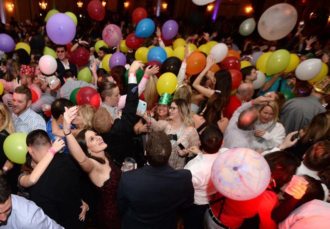 Balloons fall from the ceiling at the stroke of midnight during the New Year's Eve Bash on Dec. 31, 2016, at the Ambassador Conference Center in Summit Township.