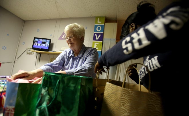 Volunteer Evelyn Morehead helps wrap gifts for children who are spending Christmas at the Lighthouse Women’s Shelter on Friday. [Brittany Randolph/The Star]