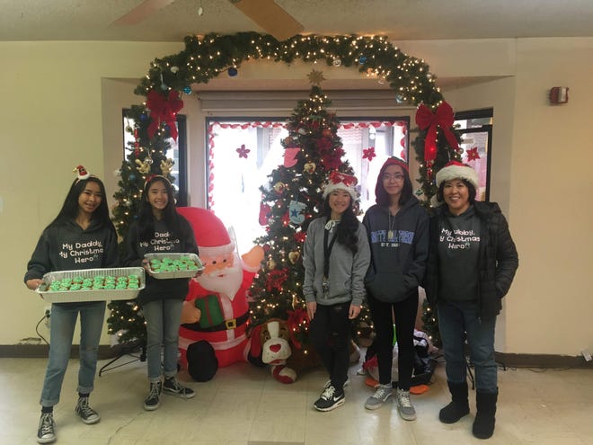 Judith Claridad,right, and her daughters brought warm clothing and Christmas cupcakes to the High Desert Homeless Services shelter in Victorville recently. Claridad said the donation was in honor of her husband, Claro, who died 10 years ago after saving the lives of two children on Christmas Day. [Photo courtesy Judith Claridad]