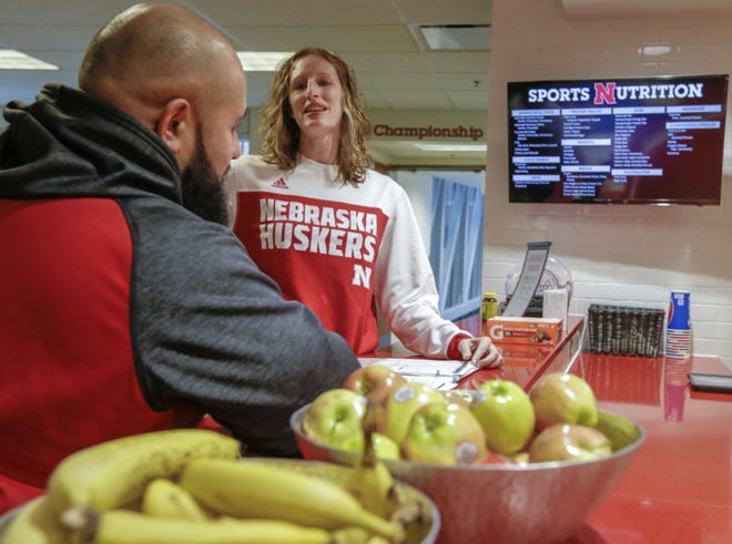 In this Jan. 2017, photo, Lindsey Remmers, University of Nebraska's director of performance nutrition, speaks to Mark Philipp, head football strength coach, in Lincoln, Neb. Nebraska will spend $3.3 million this year on athlete nutrition. In addition to the high-quality food at the training table and healthy snacks at fueling stations, the budget covers a director of food service, executive chef, registered sports dietitian and three assistants and more than a dozen other staffers. (AP Photo/Nati Harnik)