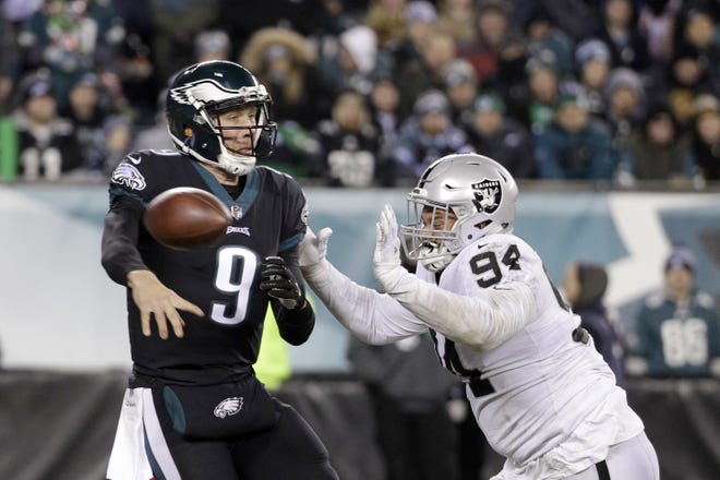 Philadelphia Eagles' Nick Foles tries to pass against Oakland Raiders' Eddie Vanderdoes Monday night in Philadelphia. Foles had a rough outing in his second start in place of injured quarterback Carson Wentz, completing just 19 of 38 passes in windy conditions. [CHRIS SZAGOLA / THE ASSOCIATED PRESS]