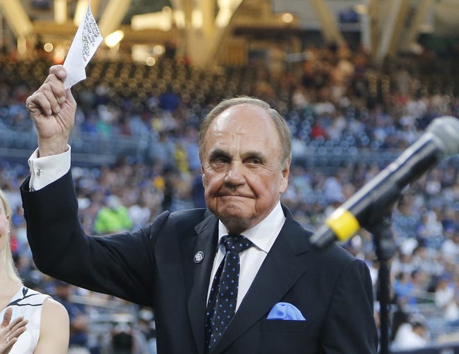 FILE - In this Sept. 29, 2016, file photo, San Diego Padres broadcaster Dick Enberg waves to crowd at a retirement ceremony prior to the Padres' final home baseball game of the season, against the Los Angeles Dodgers in San Diego. Enberg, the sportscaster who got his big break with UCLA basketball and went on to call Super Bowls, Olympics, Final Fours and Angels and Padres baseball games, died Thursday, Dec. 21, 2017. He was 82. Engberg's daughter, Nicole, confirmed the death to The Associated Press. She said the family became concerned when he didn't arrive on his flight to Boston on Thursday, and that he was found dead at his home in La Jolla, a San Diego neighborhood. (AP Photo/Lenny Ignelzi, File)