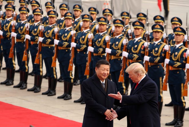 FILE - In this Nov. 9, 2017, file photo, President Donald Trump and Chinese President Xi Jinping participate in a welcome ceremony at the Great Hall of the People in Beijing, China. Trump couldn’t seem to stop talking about the red carpets, military parades and fancy dinners that were lavished upon him during “state visits” on his recent tour of Asia. “Magnificent,” he declared at one point on the trip. But Trump has yet to reciprocate in kind. In fact, he is the first president in decades to close his first year in office without welcoming a counterpart on a visit to the U.S. with similar trappings. (AP Photo/Andrew Harnik, File)