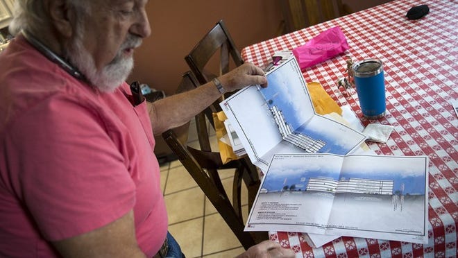 Allen Reichler shows documents detailing the structure of a proposed apartment complex to be built near his home. Developers plan to build a nearly 100-unit apartment complex on properties directly behind Reichler’s backyard upon city approval of the plans. NICK WAGNER / AMERICAN-STATESMAN