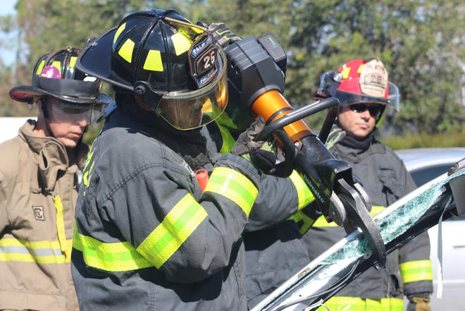 Palm Coast Firefighter Patrick Shakes trains with the new cordless vehicle extrication þÄúcutters.þÄù Pictured behind him are Firefighter Arnie Roma and Lt. James Neuenfeldt. [Photo provided/City of Palm Coast]