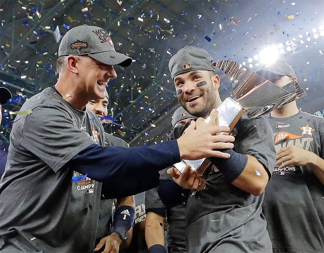 In this Oct. 21 file photo, Houston Astros manager A.J. Hinch and Jose Altuve hold the championship trophy after Game 7 of baseball’s American League Championship Series against the New York Yankees in Houston. Altuve was named The Associated Press Male Athlete of the Year on Wednesday. [DAVID J. PHILLIP/ASSOCIATED PRESS]