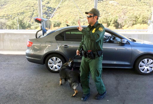 In this Thursday, Dec. 14, 2017 photo, a border patrol agent stops a vehicle at a checkpoint in Pine Valley, Calif. California legalizes marijuana for recreational use on Monday, Jan. 1, 2018, but that won't stop federal agents from seizing small amounts on busy freeways and backcountry highways. Marijuana possession will continue to be prohibited at eight Border Patrol checkpoints in California, a reminder that state and federal law collide when it comes to pot. (AP Photo/Elliot Spagat)